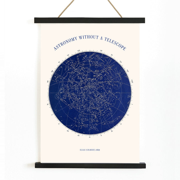 Star map and poster of constellations titled Astronomy without a Telescope by Elias Colbert featuring celestial star chart in blue, with wooden magnetic frame on white background