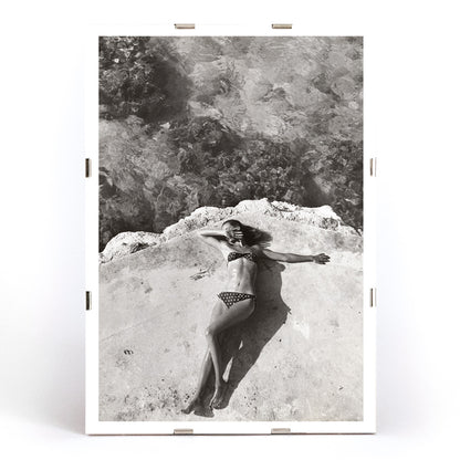 Woman in bikini lying on platform near water in Montego Bay Jamaica artwork by Nickerson Paine poster, framed and displayed in modern living room decor