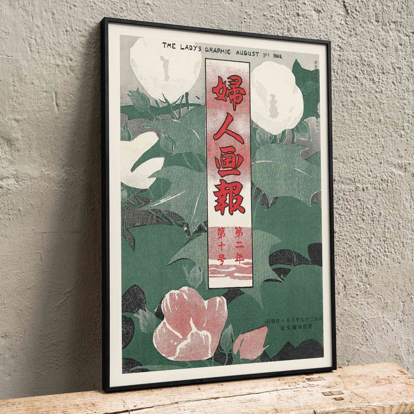 The Lady Graphic by Mitsutani Kunishiro poster with white flowers, green leaves, red lettering, and botanical foliage, framed and displayed in home decor