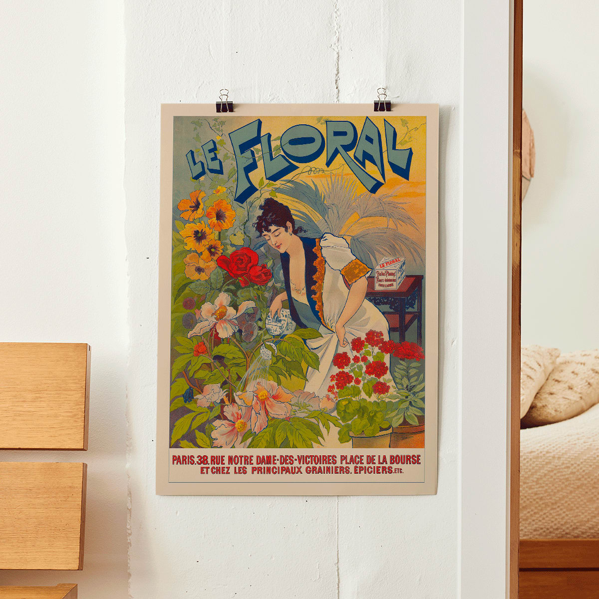Le Floral poster featuring a woman tending and watering vibrant colorful flowers with bold Le Floral text in the background, framed and displayed in home decor