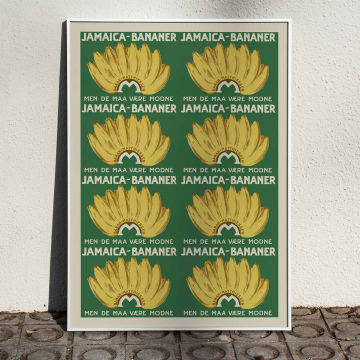 Jamaica Bananas poster with repeated ripe yellow banana bunches on a deep green vintage advertising design, framed and displayed in home decor