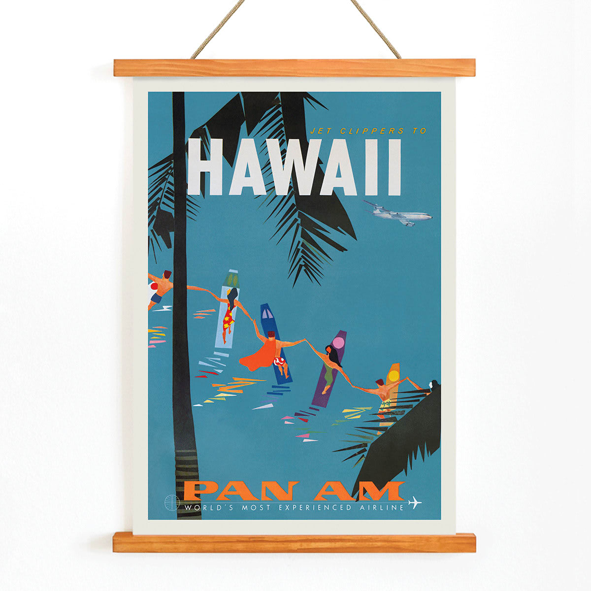 Colorful travel poster Jet Clipper to Hawaii by Pan Am Airlines with palm trees surfers dancers on surfboards and airplane above palm leaves, with wooden magnetic frame on white background