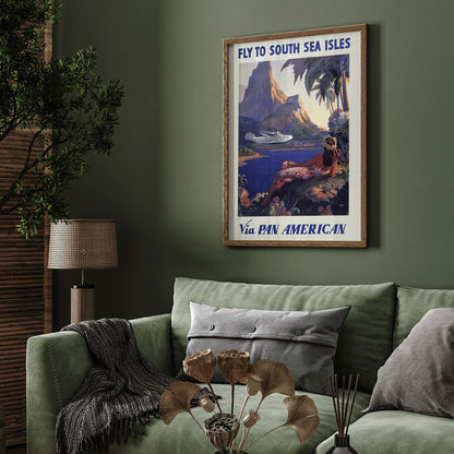 Vintage travel poster of a woman in a floral dress on a tropical island with a Pan American seaplane by Paul George Lawler, framed and displayed in home decor