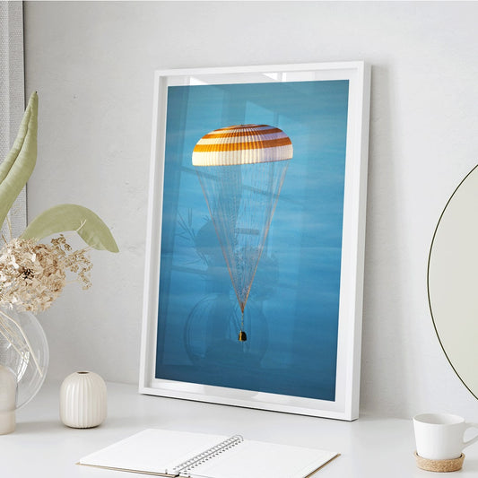 Soyuz TMA-14M spacecraft descending with parachute against blue sky NASA Expedition 42 landing poster artwork, framed and displayed in home decor