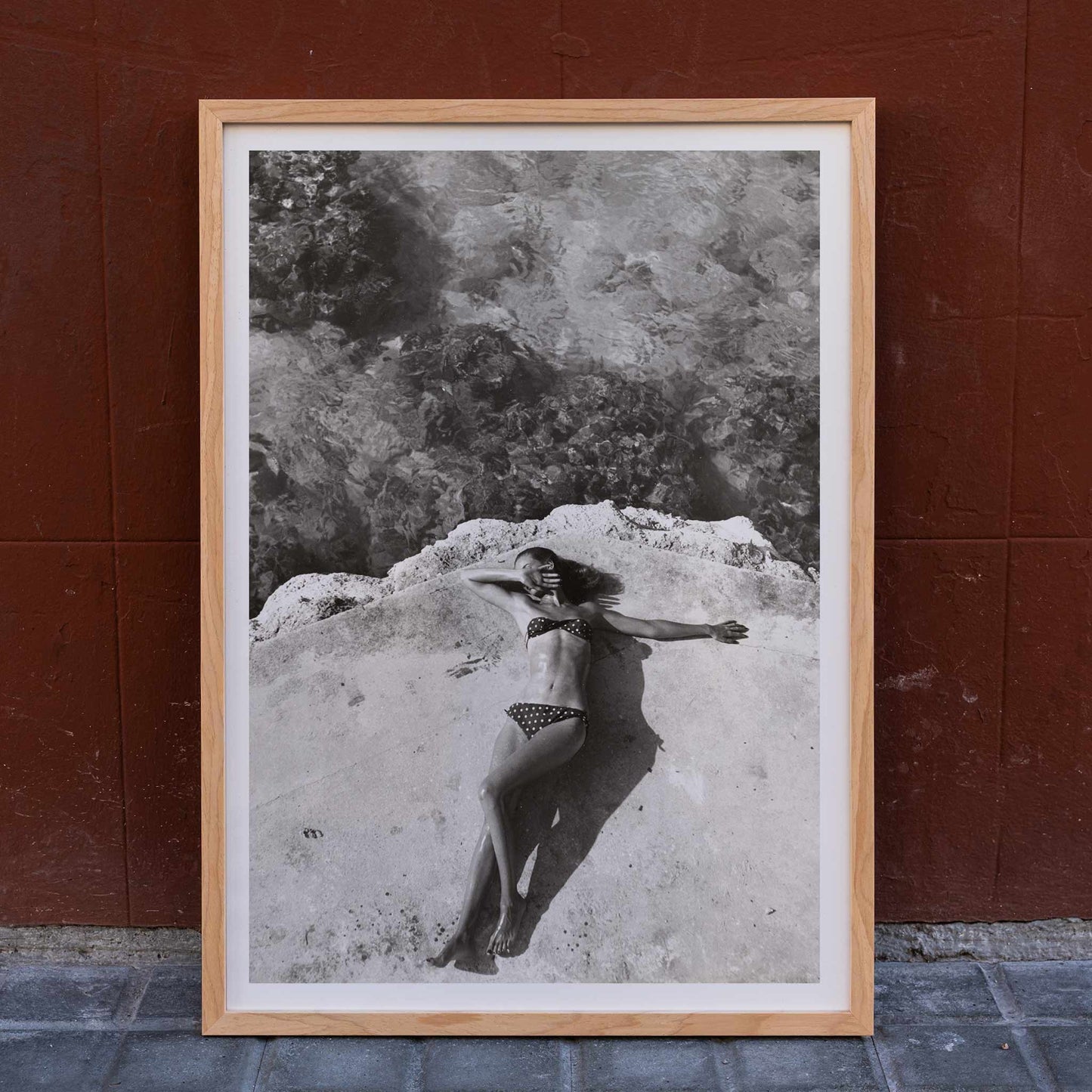 Woman in bikini lying on platform near water in Montego Bay Jamaica artwork by Nickerson Paine poster, framed and displayed in home decor