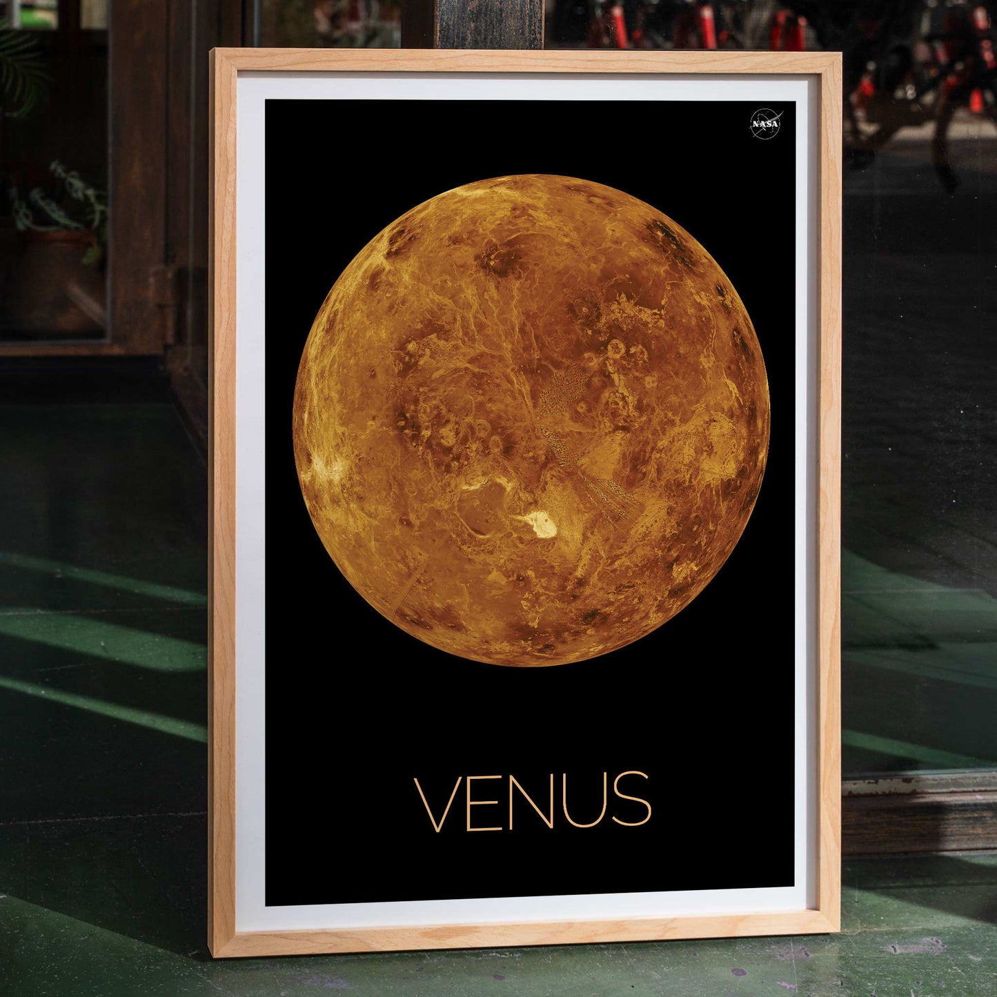 Planet Venus illustration and poster by NASA showing a detailed orange and brown view of the planet on a black background, framed and displayed in home decor
