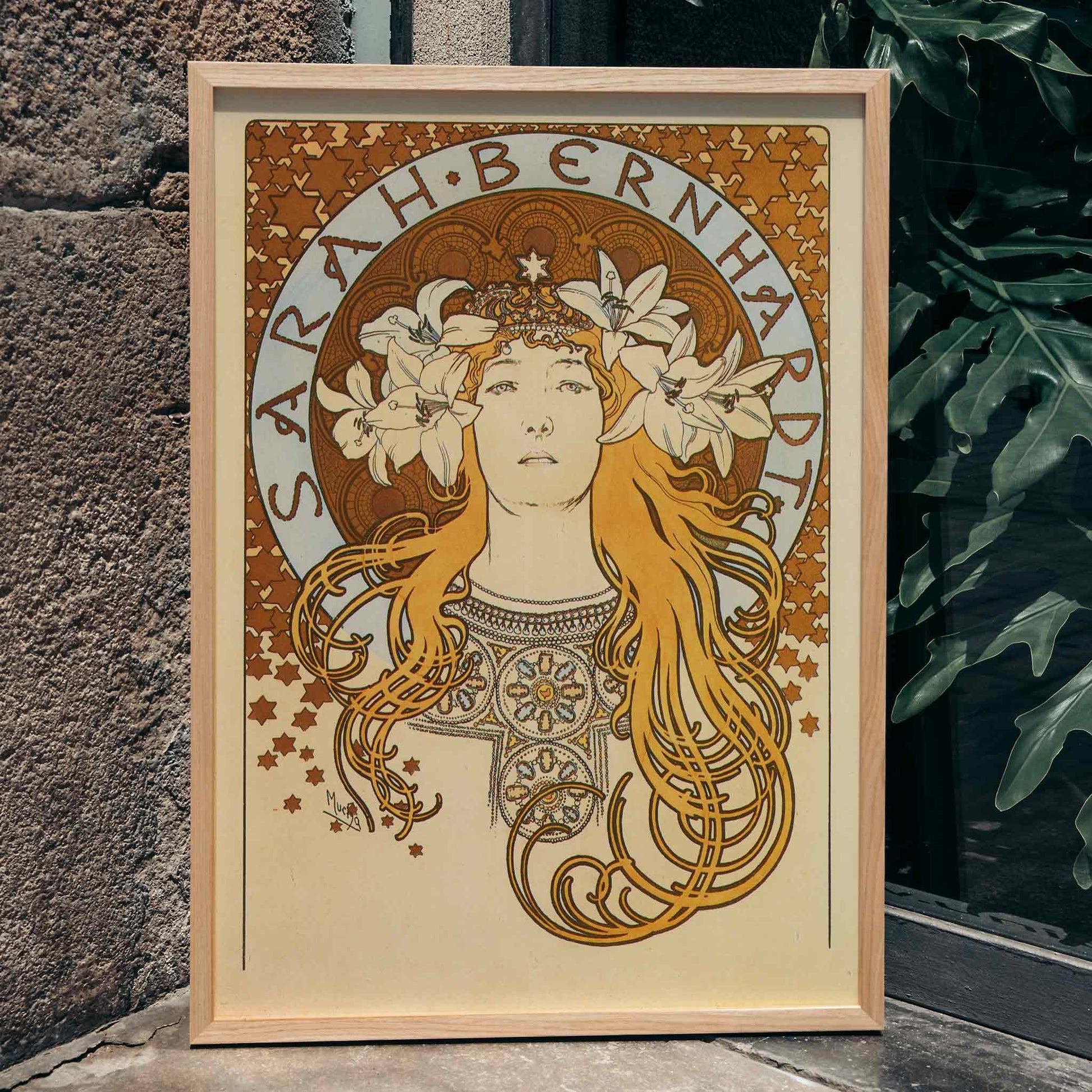 Art Nouveau poster of Sarah Bernhardt with flowing hair floral crown and lilies by Alphonse Mucha from La Plume, framed and displayed in home decor