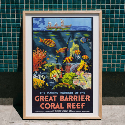Colorful coral reef and tropical fish with people in a boat above artwork The Marine Wonders of the Great Barrier Coral Reef by Percival Albert Trompf, framed and displayed in home decor