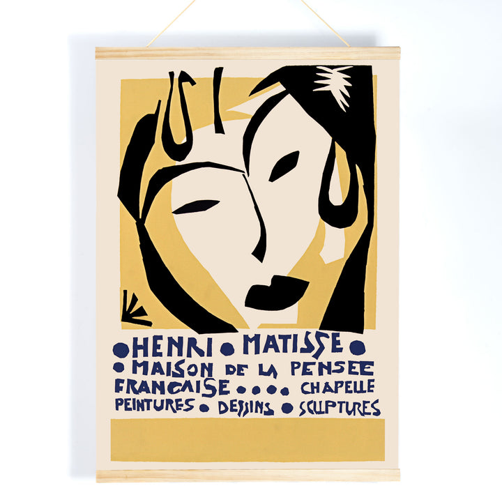 Henri Matisse Maison de la Pensee francaise poster with bold black abstract face shapes on warm yellow and cream minimalist design, with wooden magnetic frame on white background