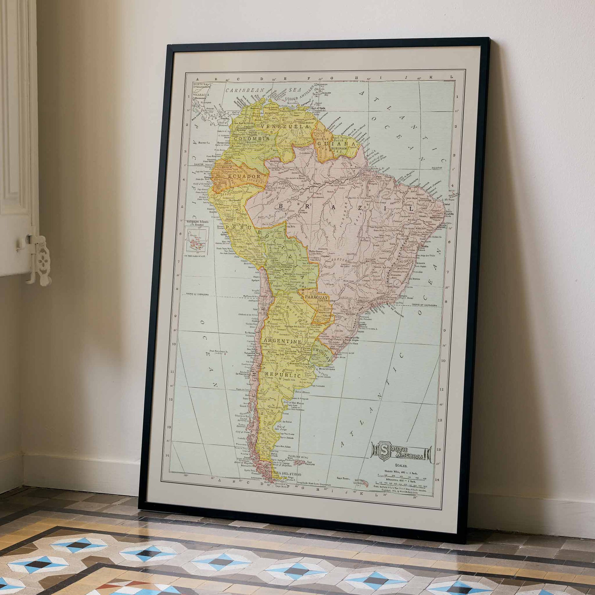 Vintage Rand McNally South America map poster with labeled continent in soft yellow pink and beige cartographic detail, with wooden magnetic frame on white background