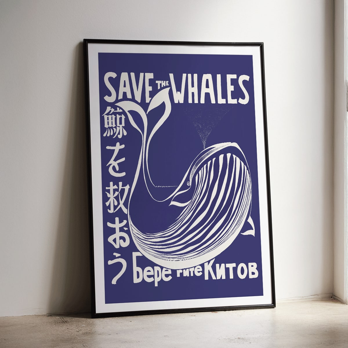 Save the Whales poster by Lawrence Vint featuring a stylized white whale and multilingual save the whales message on blue background, framed and displayed in home decor