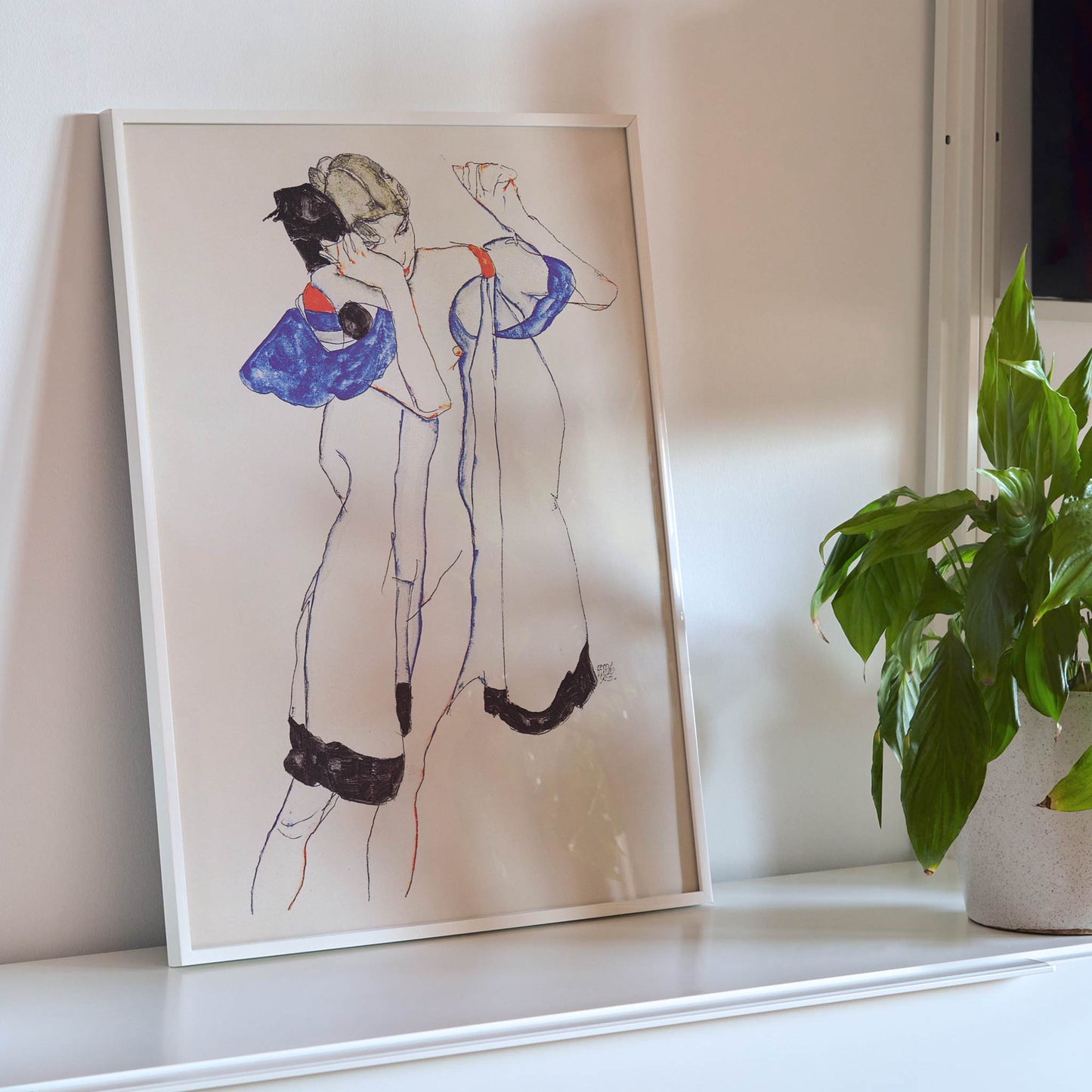 Egon Schiele Woman in a Morning Robe poster with delicate expressionist figure in white blue and black on beige background, framed and displayed in modern living room decor